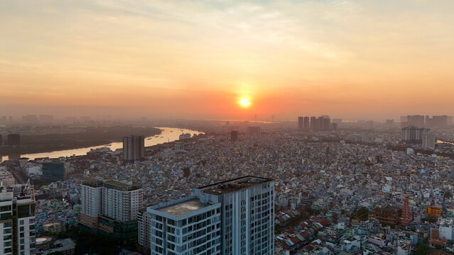 Ho Chi Minh City, Vietnam &ndash; 4K aerial sunrise drone view of downtown skyline with modern skyscrapers, dense urban housing, busy streets and morning traffic along the Saigon River in Southeast Asia