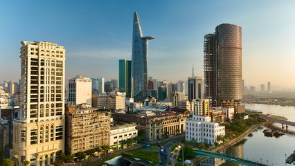 Ho Chi Minh City, Vietnam – 4K aerial sunrise drone view of downtown skyline with modern skyscrapers, dense urban housing, busy streets and morning traffic along the Saigon River in Southeast Asia © Thomas