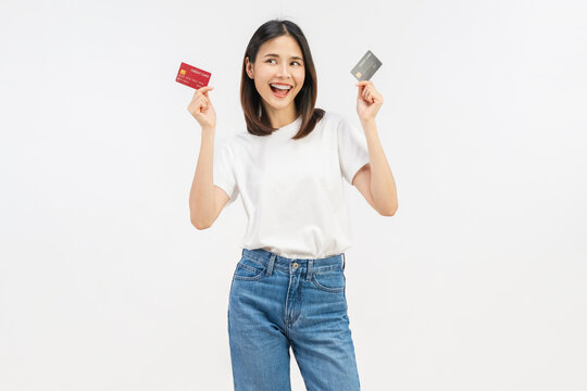 Happy young Asian woman holding credit cards with a confident smile isolated on white studio background.