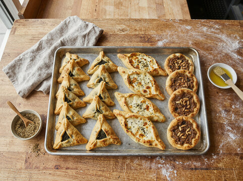 Traditional middle eastern fatayer pastries on a baking sheet tray