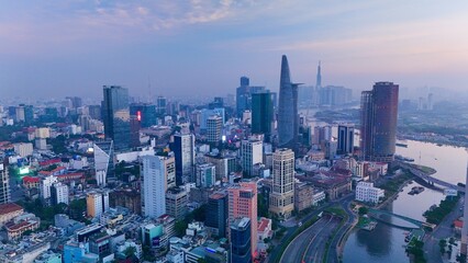 Ho Chi Minh City, Vietnam – 4K aerial sunrise drone view of downtown skyline with modern skyscrapers, dense urban housing, busy streets and morning traffic along the Saigon River in Southeast Asia © Thomas