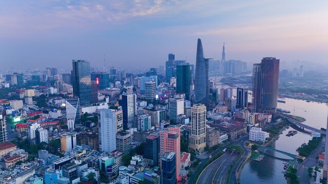 Ho Chi Minh City, Vietnam &ndash; 4K aerial sunrise drone view of downtown skyline with modern skyscrapers, dense urban housing, busy streets and morning traffic along the Saigon River in Southeast Asia