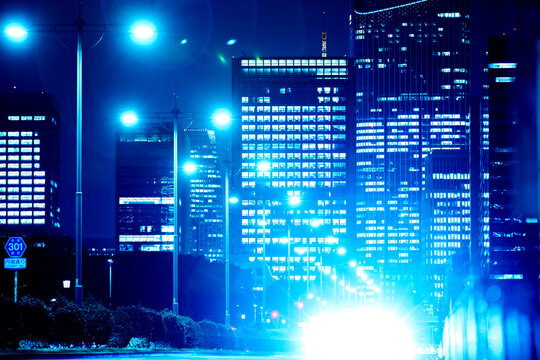 Intense headlights and glowing skyscrapers on Uchibori-dori street in Tokyo's financial center.
