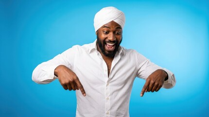 Naklejka premium Excited man with a turban pointing down at copy space