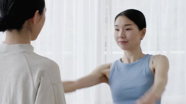 Asian Woman Yoga Instructor Checking Student Posture