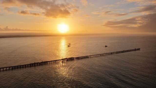 Beachport, South Australia at sunrise: 4K aerial drone view of coastal town, jetty, calm ocean, Southern Ocean Beach and golden morning light.
