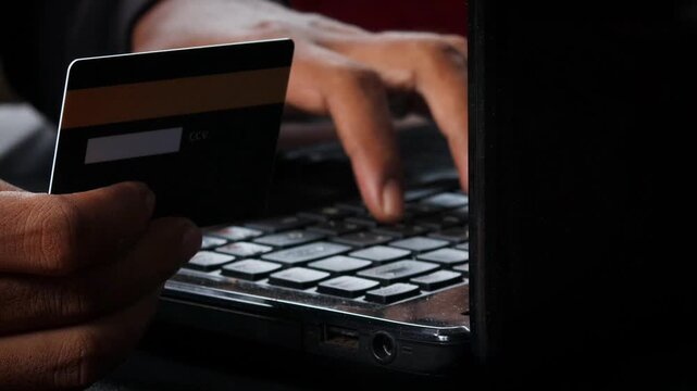 Credit Cards Theft. Hacker with Credit Cards on His Laptop Using Them For Unauthorized Shopping. Unauthorized Payments. Stolen Credit Cards Concept.