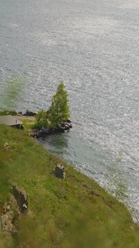 View of the sea and the coastline. Half of the frame is the sea, half is the shore. Vertical shot.