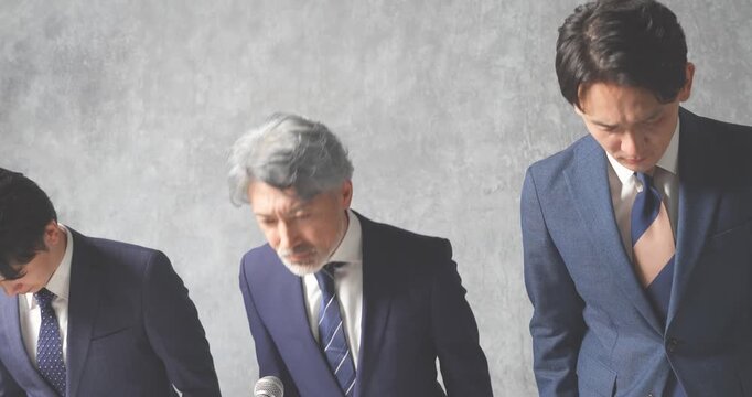 謝罪会見をするスーツ姿の会社員