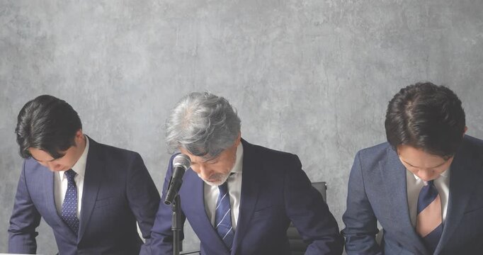 謝罪会見をするスーツ姿の会社員