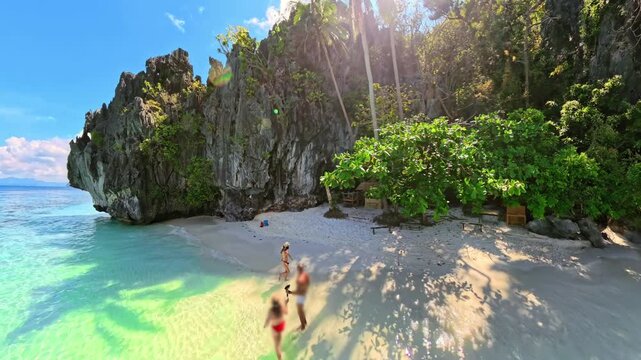 Entalula Beach in El Nido, Philippines, limestone cliffs, vibrant tropical vegetation, in crystal-clear turquoise waters under sunny blue sky of Palawan island