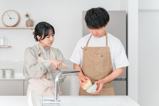 A couple arguing or fighting in the kitchen.