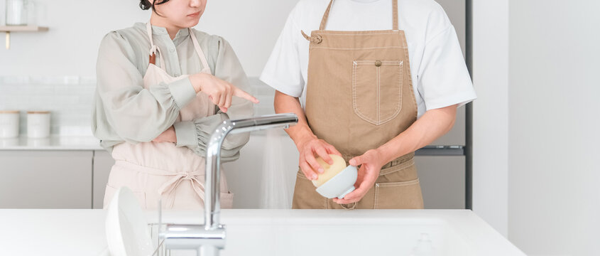 A couple arguing or fighting in the kitchen.