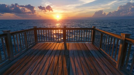 Fototapeta premium Empty wooden deck overlooking a calm ocean with a dramatic golden sunset sky on the horizon