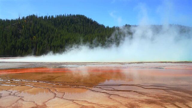 Grand Prismatic Spring vibrant hot springs pool Midway Boardwalk hiking trail Mid Geyser Basin Wyoming USA Yellowstone National Park nature landscape Opal Pool Morning Glory sunny morning blue sky pan