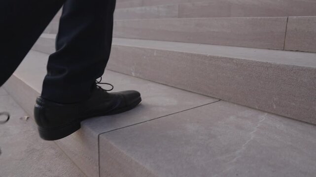 Business man walking stairs with each step closer to success. Businessman climbing stairs step by step in business. Business man taking a step forward on stairs. Businessman walking stairs.