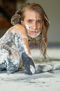 Close up portrait of woman with expressive paint textures on skin creating abstract artistic patterns, strong contrast and creative visual impact in a studio setting