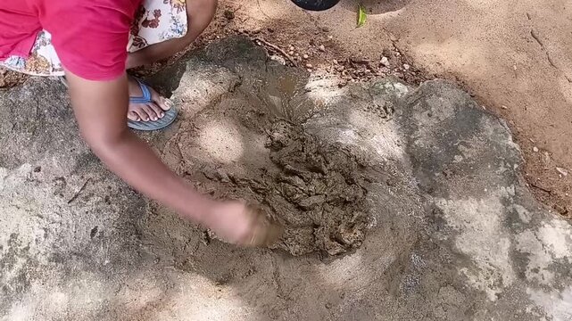 Mixing Natural Cow Dung And Clay With Water By Hand To Prepare The Traditional Flooring Material In A Rural Home