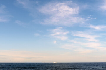 Fototapeta premium 小さな船が浮かぶ穏やかな水平線と青空