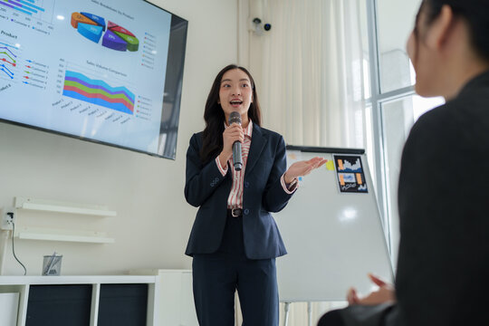 Businesswoman speaking at presentation presenting sales data