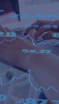 Vertical video: Hovering hands dropping to tap keys while blue tickers updating financial data