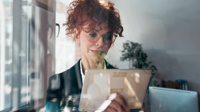 Video of elegant business woman working with digital tablet in the office