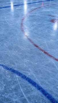 Ice rink surface with skate marks, scratched blue ice texture, hockey arena floor with red and blue lines, winter sports background