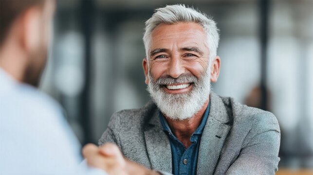 Smiling senior man in a business meeting, looking at the camera