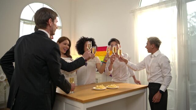 Happy LGBTQ friends raising champagne glasses together during a Pride Month celebration party at home