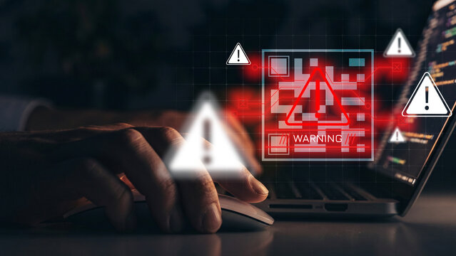 Scam message warning appears on a computer while a person uses a mouse
