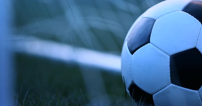 Horizontal close up of a football on the pitch at blue hour