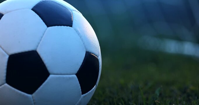 Soccer ball near goal at evening twilight