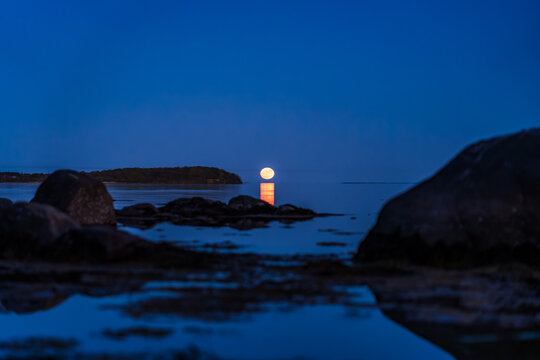 Moonrise over Water near Vilm Island on R&uuml;gen with Boulder Stones in Foreground