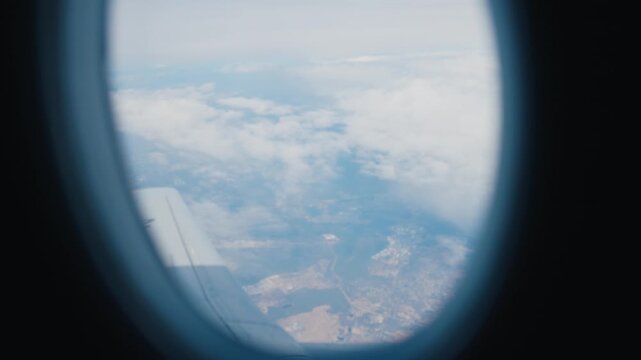 Beautiful view of slowly floating white clouds outside through airplane window. Airplane trip in summer vacation and holidays, enjoy safety and comfortable flight by airlines, traveling and tourism