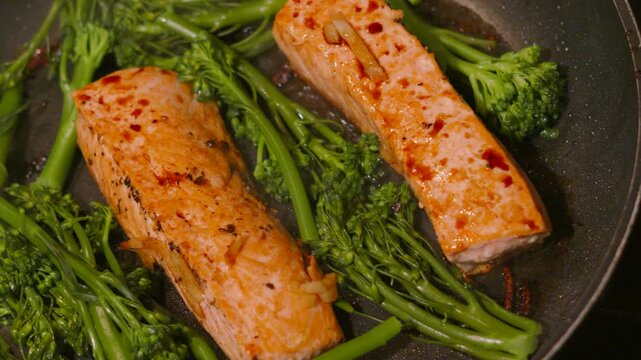Salmon Fillets Glazed in Soy Sauce with Tenderstem Broccoli in a frying pan. Ideal for culinary documentaries, healthy eating promos, or restaurant advertisements. 4K.