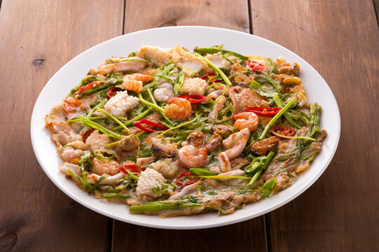 Korean Seafood Pancake, Minari Jeon with Shrimps, Squid and Water Dropwort on White Plate