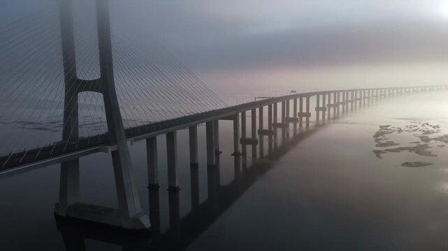 Aerial view of vasco da gama bridge over tejo river in lisbon covered by thick morning fog.