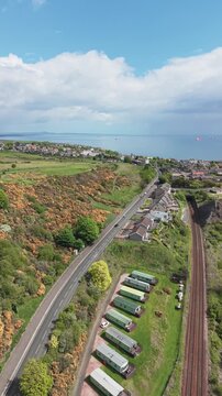 Aerial view of a coastal road and railway tracks at Pettycur Bay, Scotland.