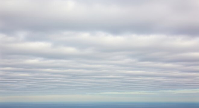 Soft Stratocumulus Clouds Hovering Above a Calm Ocean Horizon