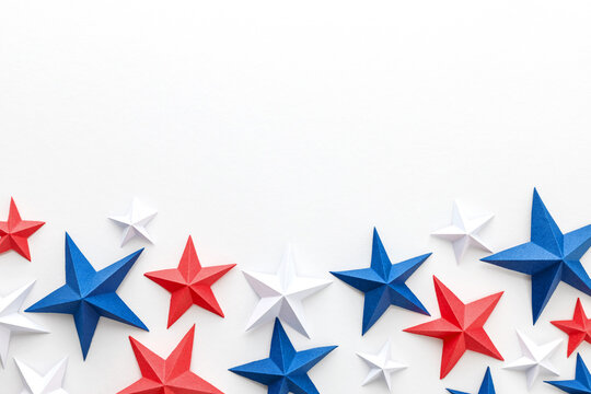 Red, white and blue origami paper stars on white background with large copy space, ideal for patriotic advertising, holiday promotions, greeting cards, invitations, banners, posters, social media