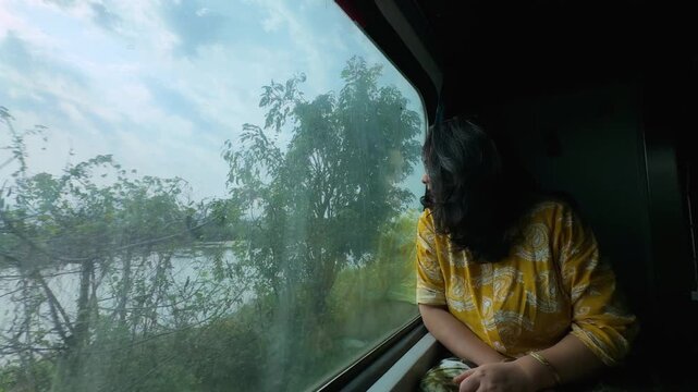 woman looking outside train window enjoying scenic journey of indian konkan railway landscape
