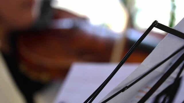 Musician playing violin with bow on stage