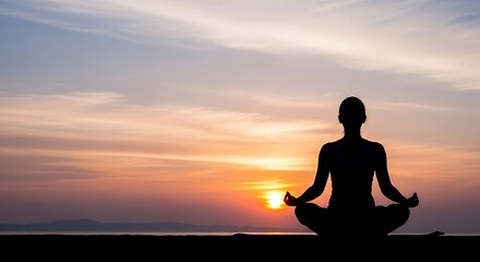 Fototapeta premium Silhouette of a woman practicing yoga meditation at sunset by the ocean