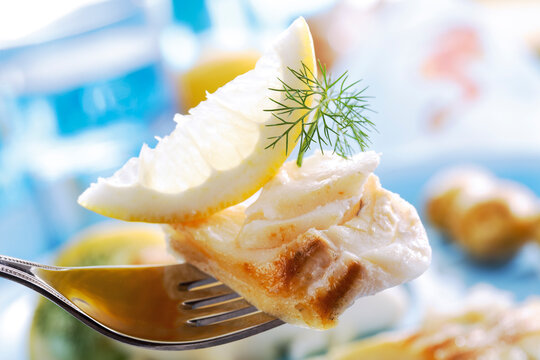 Codfish with dill and lemon slice on fork