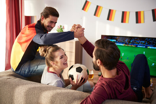 German football fans watching Tv and cheering