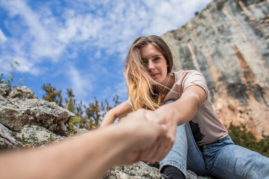 Spain, Alquezar, young woman on a hiking trip giving a helping hand