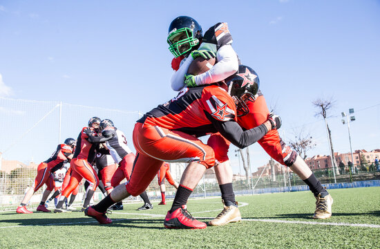 American football player being tackled by opponent player during a match