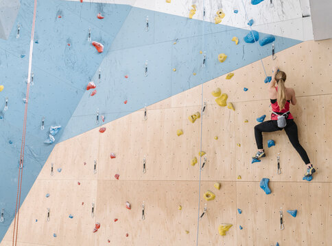 Woman climbing on the wall in climbing gym