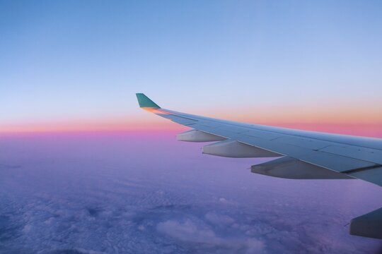 View of airplane wing over clouds