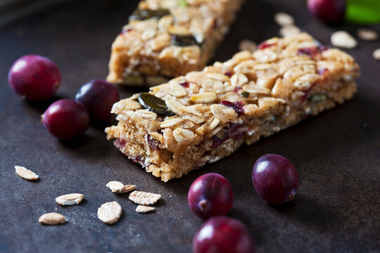 Muesli bars with cranberries and oat flakes on dark background
